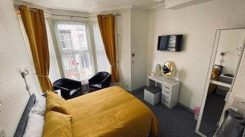 a hotel room with a yellow bed and a mirror at The Shining Diamond in Blackpool