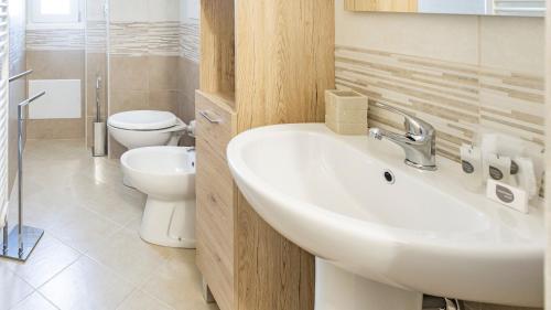 bagno con lavandino e servizi igienici di Welcomely - La Maddalena 20 ad Alghero