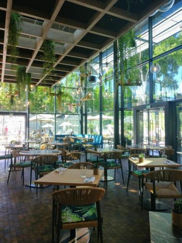 a restaurant with tables and chairs and windows at Aquabella Hôtel & Spa in Aix-en-Provence