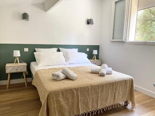 um quarto com uma cama grande e toalhas em Propriété Malva appartement agava em Alata