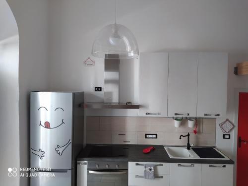 a kitchen with a refrigerator with a face drawn on it at Chez Mémé in Lesina