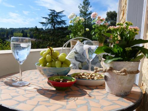 une table avec un bol de fruits et des verres à vin dans l'établissement Maison Pierre D'Or, à Sarlat-la-Canéda