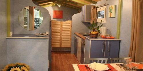 eine kleine Küche mit einem Waschbecken und einem Tisch in der Unterkunft Camping La Montagne in Sorgues