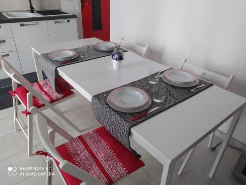 Una mesa blanca con platos en la cocina en Chez Mémé, en Lesina