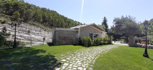 a small stone house with a grass yard at Locanda Angelica in Giarratana