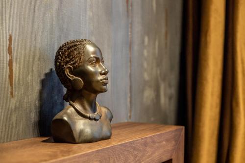 a bronze statue of a woman sitting on a wooden shelf at Bella Roe Premium Apartments in Belgrade