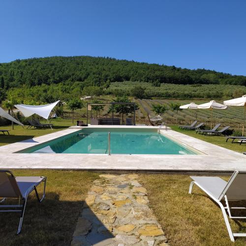 a swimming pool with two chairs and a table at Locanda Cugnanello in Anqua