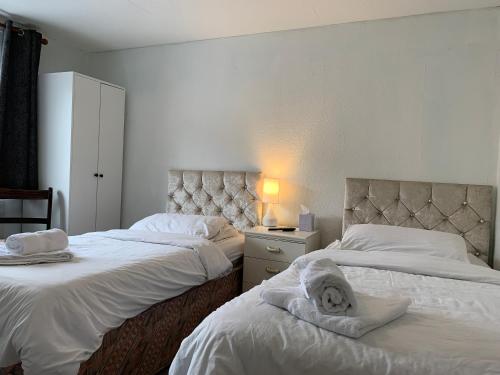 a bedroom with two beds with towels on them at St Anne's Road Guest House in Exeter