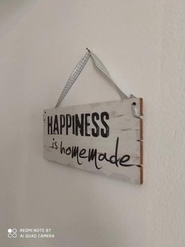 a sign that says happiness is home made hanging on a wall at Chez Mémé in Lesina