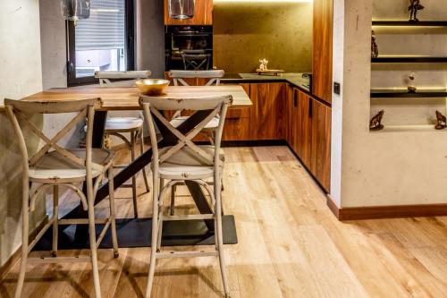 a kitchen with a wooden table and chairs at Bella Roe Premium Apartments in Belgrade