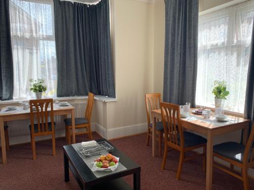 uma sala de jantar com mesa, cadeiras e janelas em St Anne's Road Guest House em Exeter
