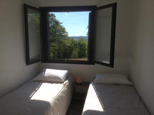 deux lits dans une chambre avec une fenêtre dans l'établissement Le chalet du Gour de Tazenat, à Charbonnières-les-Vieilles