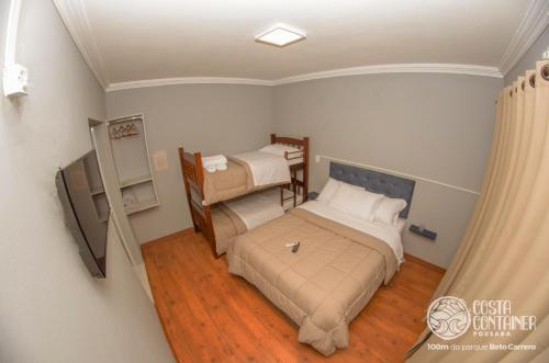 une petite chambre avec deux lits et une fenêtre dans l'établissement Pousada Costa Container, à Penha
