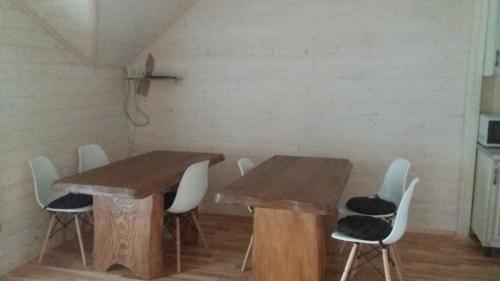 a dining room with wooden tables and white chairs at Nota Bene Mykulychyn in Mykulychyn