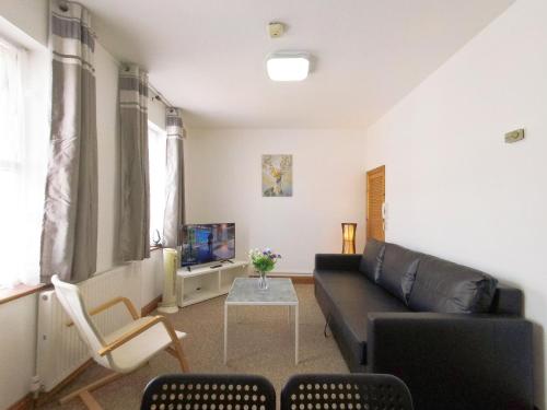 a living room with a couch and a table at Carnation Flat A in Wembley in London