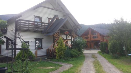 a log home with a porch and a driveway at Nota Bene Mykulychyn in Mykulychyn
