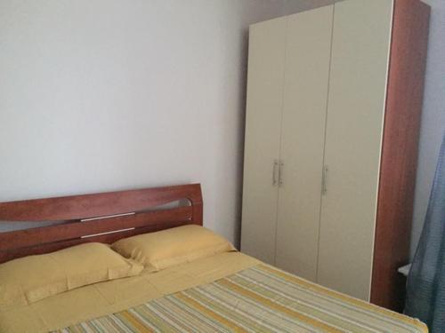 a small bedroom with a bed and a cabinet at Villa Pinna in Cavallino-Treporti