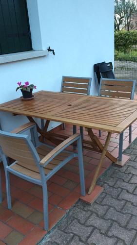 una mesa de picnic de madera con 2 sillas y una planta en Villa Pinna, en Cavallino-Treporti