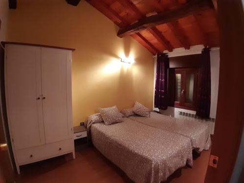 a bedroom with a bed and a cabinet in it at Vivienda Turistica La Catedral in Santo Domingo de la Calzada