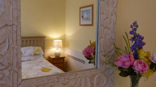 a bedroom with a mirror and a bed with flowers at Maison Pierre D'Or in Sarlat-la-Canéda