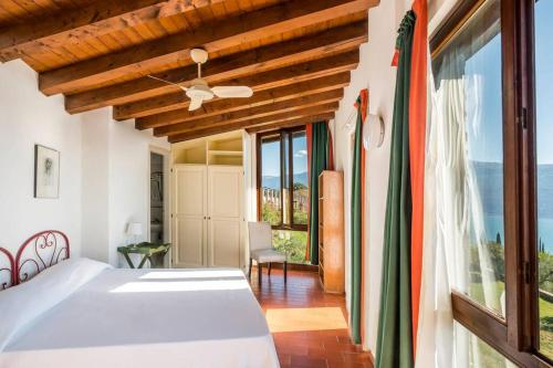- une chambre avec un lit et une grande fenêtre dans l'établissement Villa Limonaia, à Gargnano