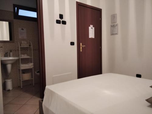 a bedroom with a bed and a sink and a door at b&b La Lucertola casa vacanze in Carovigno