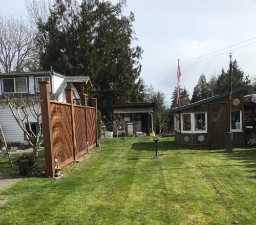 a yard with a house and a fence at Lantzville Treehouse in Lantzville