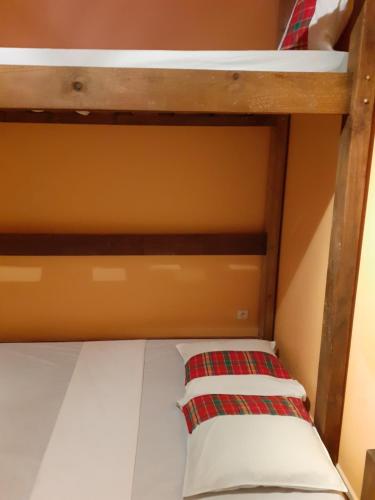 a bunk bed with a red and white pillow on it at Martinique hostel in Sainte-Luce