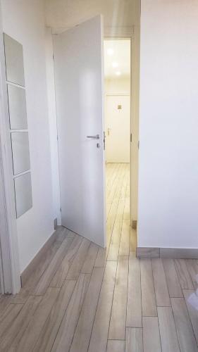 an empty room with a white door and a wooden floor at Pepi B&B in Santa Maria di Castellabate