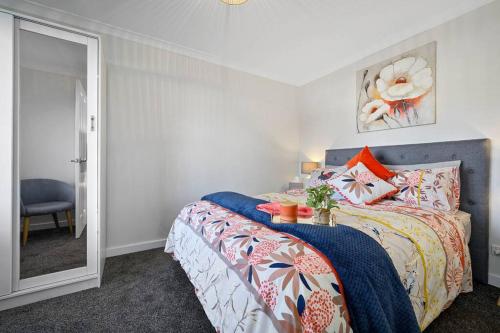 1 dormitorio con cama y espejo en Zoo Villas: Villa Giraffe - Central Wynyard, en Wynyard