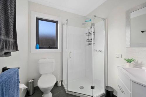 La salle de bains est pourvue de toilettes et d'une douche en verre. dans l'établissement Zoo Villas: Villa Giraffe - Central Wynyard, à Wynyard