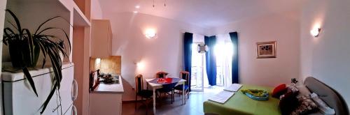 a living room with a green couch and a table at Apartments Luxor in Rogoznica