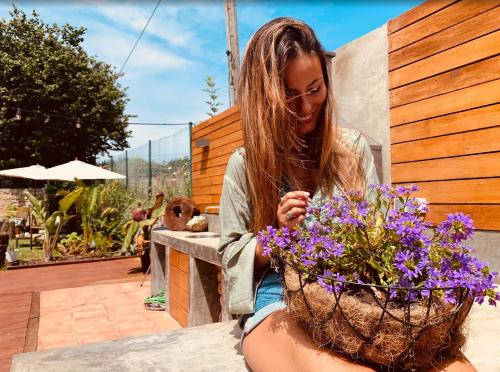 a woman sitting next to a basket of purple flowers at Las Casitas de Santillana in Santillana del Mar