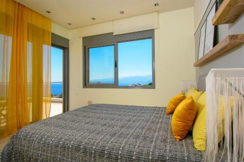 a bedroom with a bed with yellow pillows at Anemos Elounda Villas in Elounda