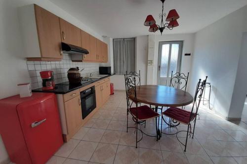 Courcelles-lès-Gisors的住宿－la maison de maxime，厨房配有桌子和红色冰箱
