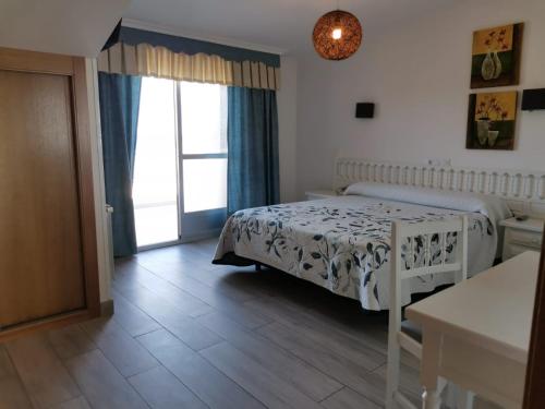a small bedroom with a bed and a window at Hotel Estrella del Mar in A Lanzada