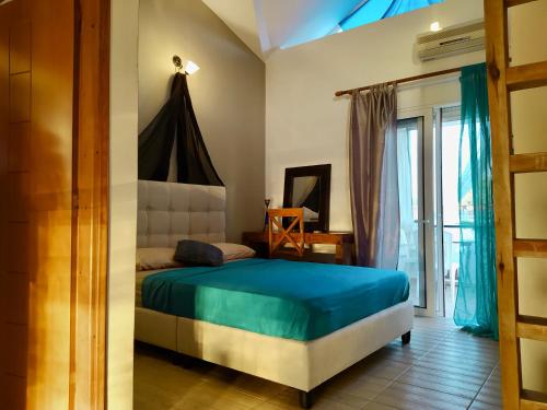um quarto com uma cama com uma colcha azul em Michaella's Maissonete at Rafaella Resort em Kokkónion