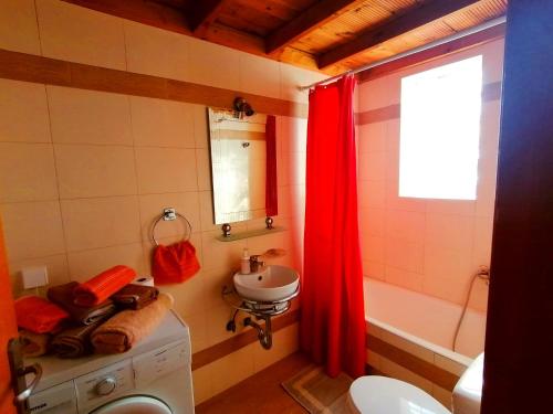 uma casa de banho com um lavatório, um WC e uma cortina vermelha em Michaella's Maissonete at Rafaella Resort em Kokkónion