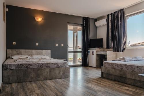 a bedroom with two beds and a large window at Calisto Villas Arapya in Arapya
