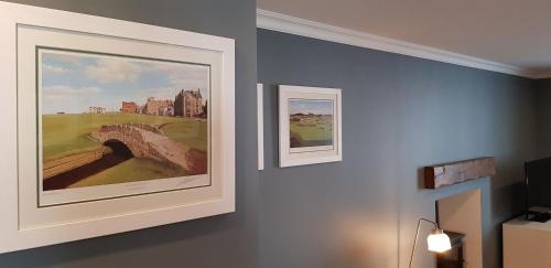 two framed pictures of a golf course on a wall at Courtyard at Crail in Crail