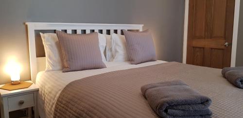 a bedroom with a large bed with a lamp on a table at Courtyard at Crail in Crail