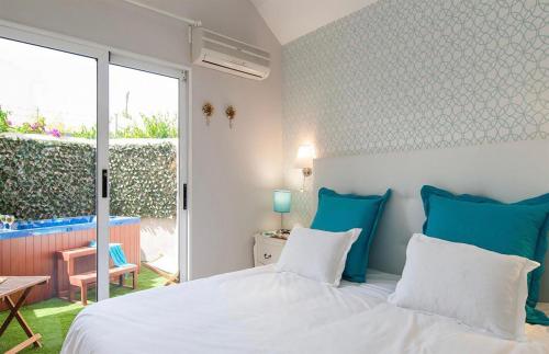 a bedroom with a bed with blue and white pillows at Flamboyant Tree Garden Holiday Home in Maspalomas