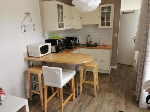 a kitchen with a wooden table with a microwave on it at Studio des Stuarts in Dol-de-Bretagne