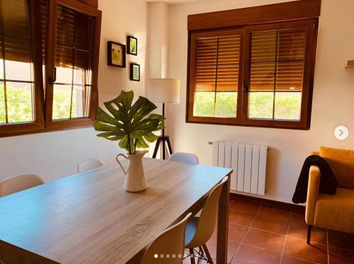 a dining room table with a plant in a vase at Las Casitas de Santillana in Santillana del Mar