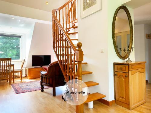 a spiral staircase in a living room with a mirror at Quiet apartments in Tempelhof in Berlin