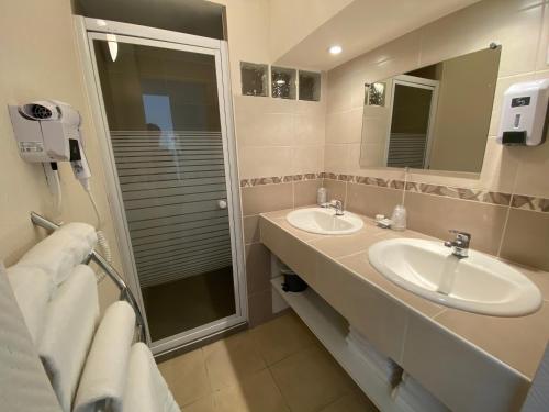 a bathroom with a sink, mirror, and bathtub at Hotel de Bretagne in Fougères