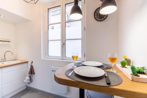 沙特尔Cocon à Bulles Chic vue Cathédrale avec Spa-jacuzzi的厨房配有一张桌子和两杯葡萄酒
