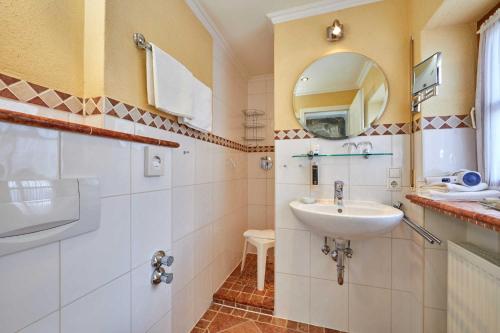 a bathroom with a sink and a mirror at Landhotel zum Bad in Krün