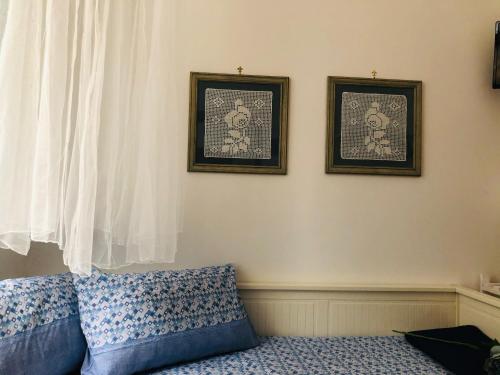 a room with a couch and two pictures on the wall at A Casa di Claudia in Naples