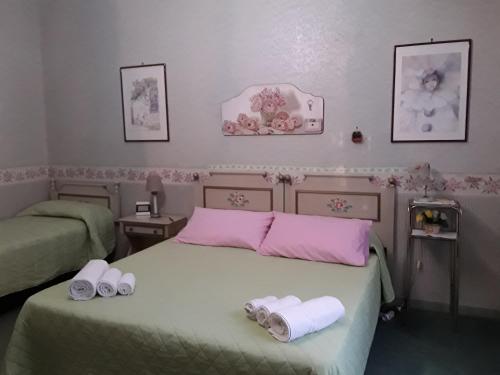 a bedroom with two beds with towels on them at AmbraBed Lunghezza Station in Lunghezza